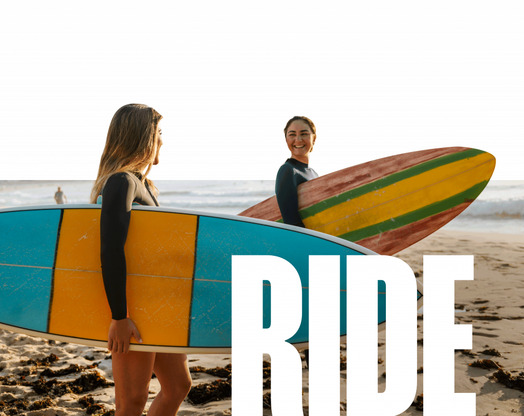 two ladies holding surf boards with the word RIDE overlaid