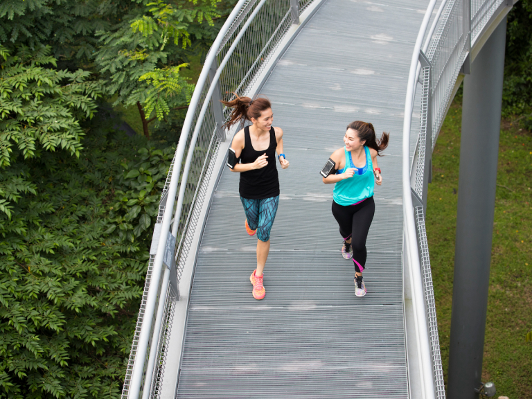 two women running on foot bridge